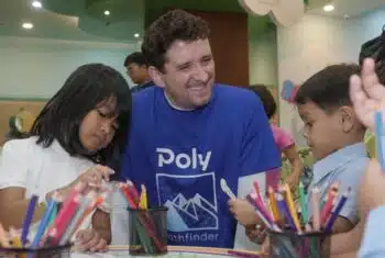 Teacher George sitting at a table with young students in classroom in Indonesia