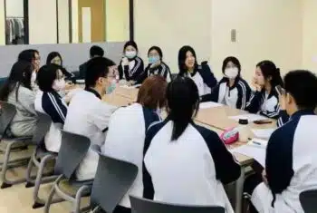 Chinese students sitting at a desk in a classroom