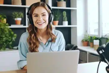 Female teacher with headphones, laptop and microphone, teaching English online